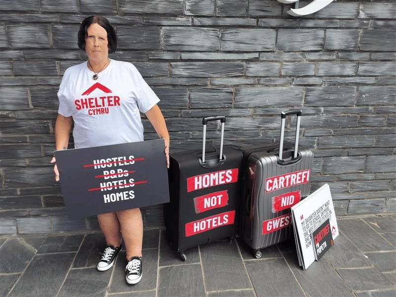 Lady holding board with suitcases