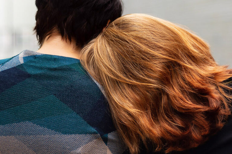 Person resting head on friends shoulder