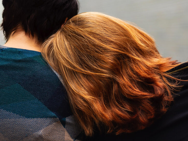 Person resting head on friends shoulder