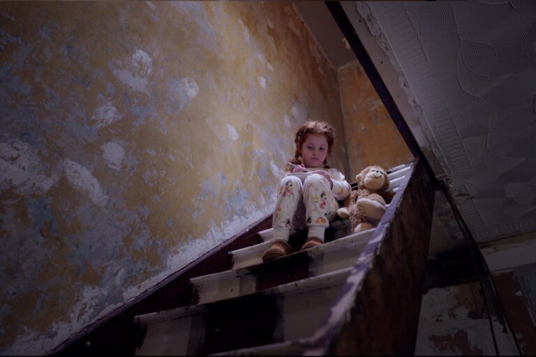 Little girl sitting on stairs