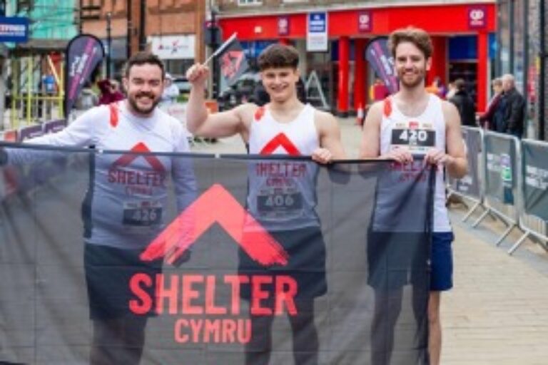 Runners holding SHELTER flag